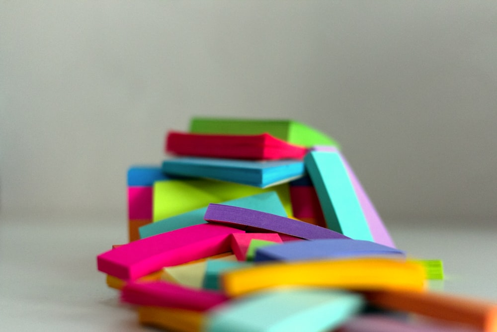 a pile of colored post it notes sitting on top of a table