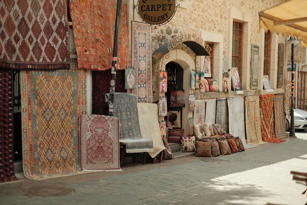 Un frente de tienda con muchas alfombras y tapetes en exhibición