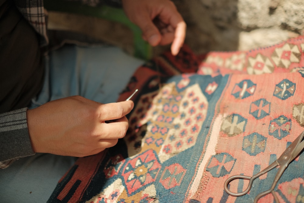 a person cutting a piece of fabric with scissors