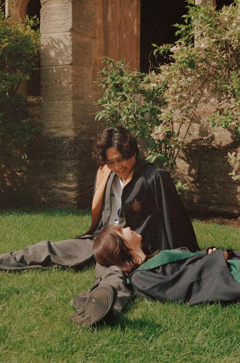 a man and a woman laying on the grass