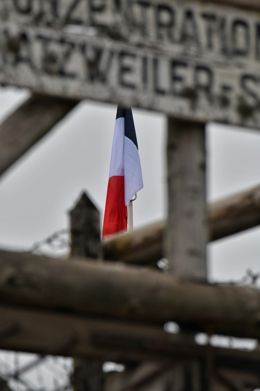 a wooden sign with a flag hanging from it's side