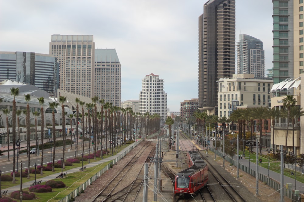 a train traveling down train tracks next to tall buildings