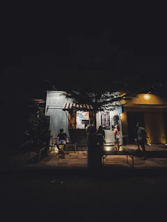 A vibrant street food stand with a friendly chef serving customers under warm lighting.