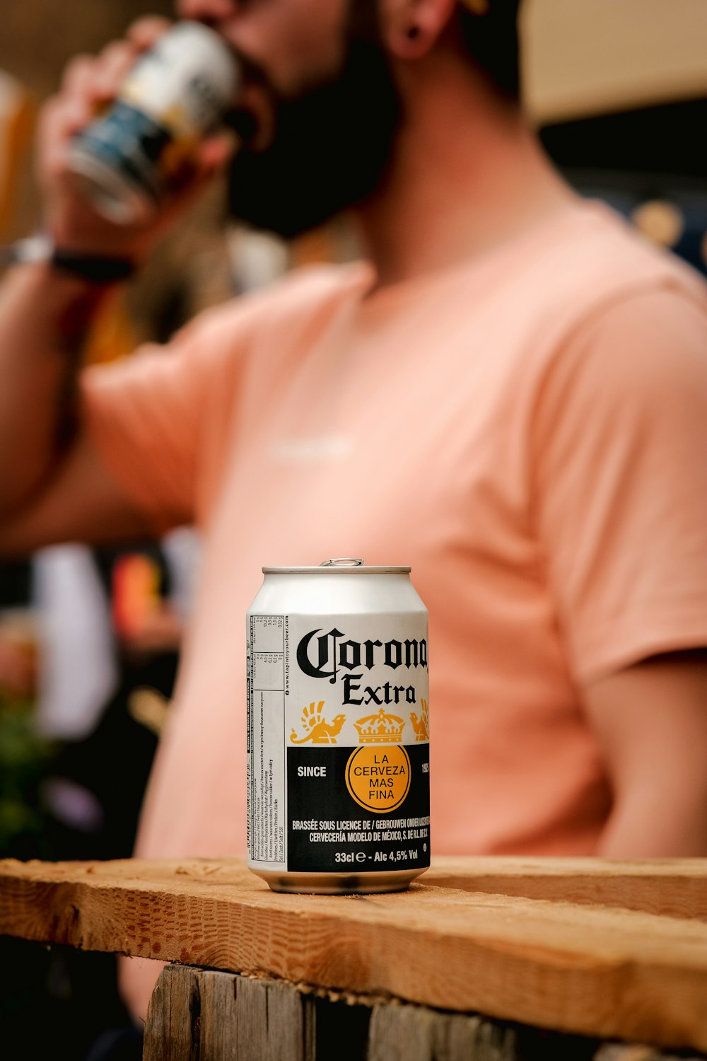 a man drinking a corona beer from a can