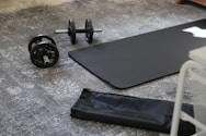 a pair of dumbbells and a black mat on the floor