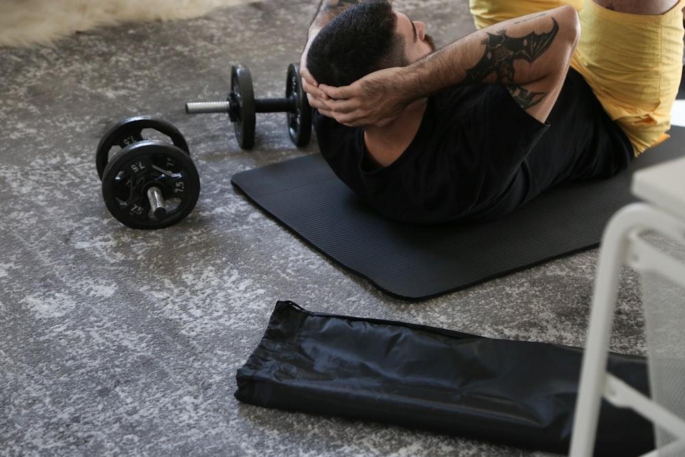a man is doing exercises on a mat with a barbell