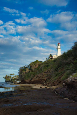 Dramatic view of Cap Spartel lighthouse where the Atlantic Ocean meets the Mediterranean under a bright blue sky.