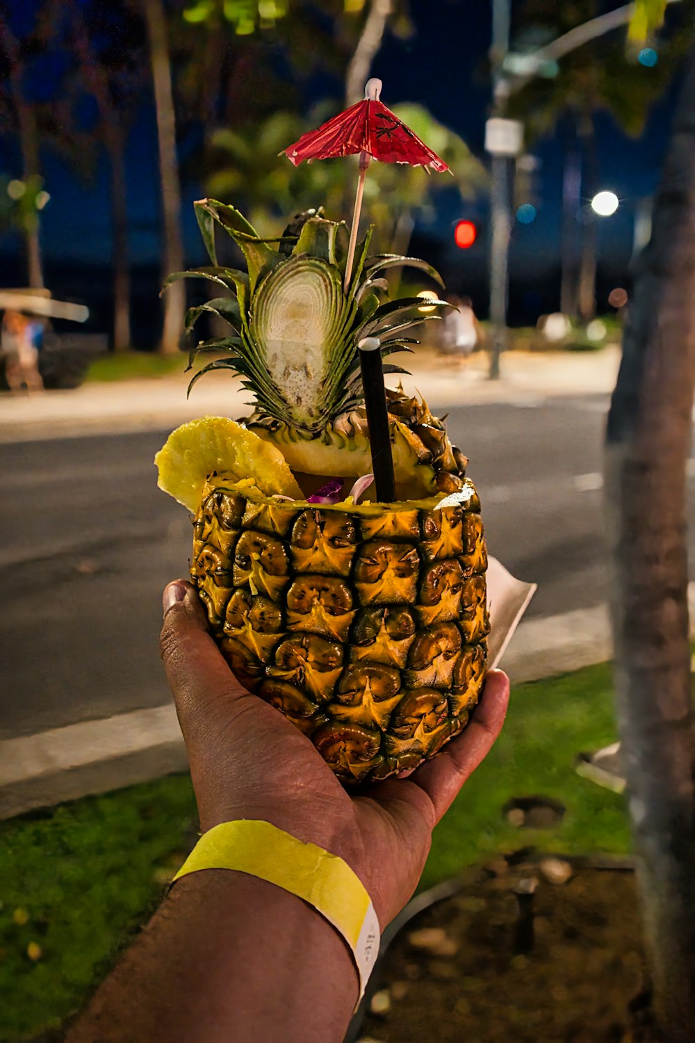 a person holding a pineapple with a slice of fruit in it