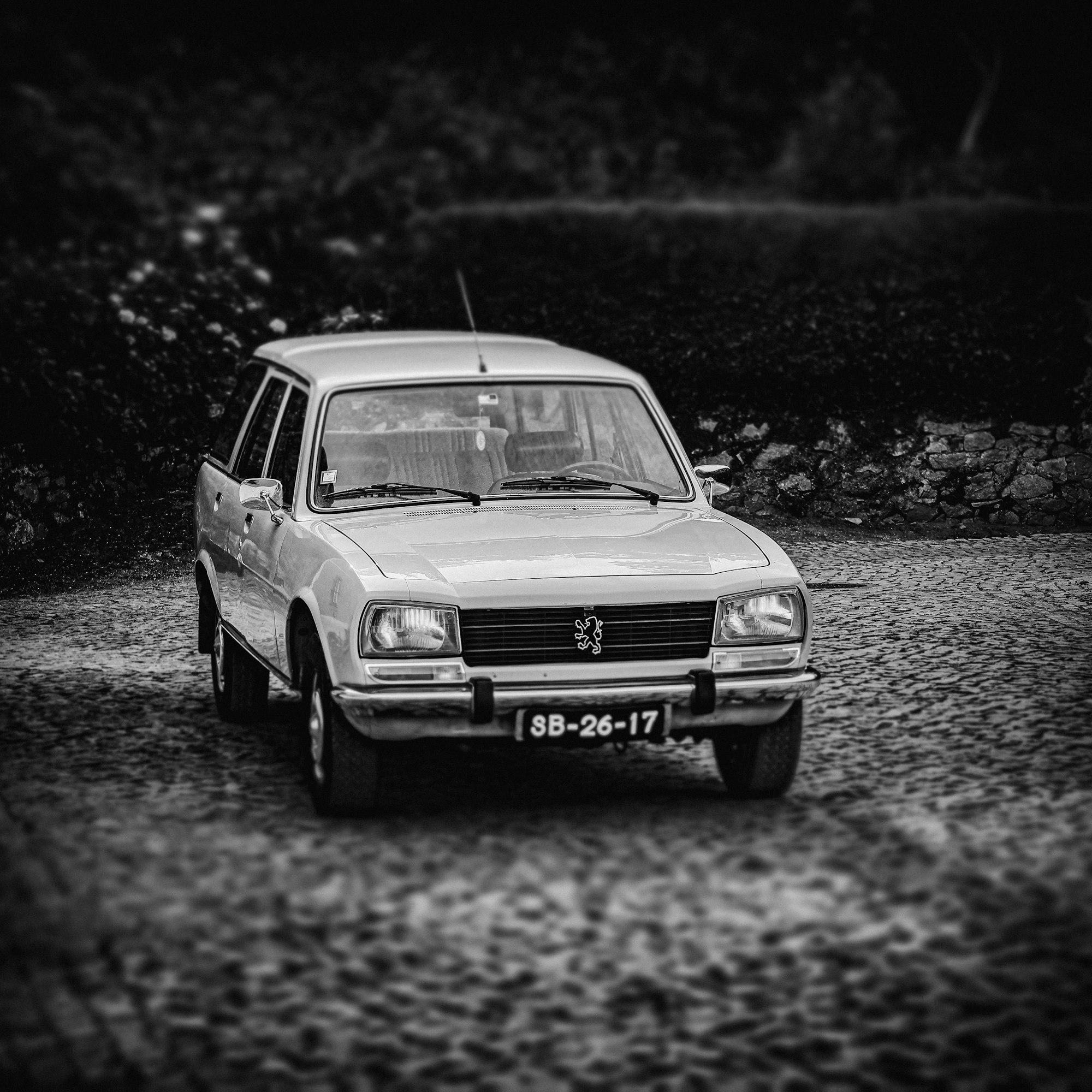 a white car is parked on a gravel road