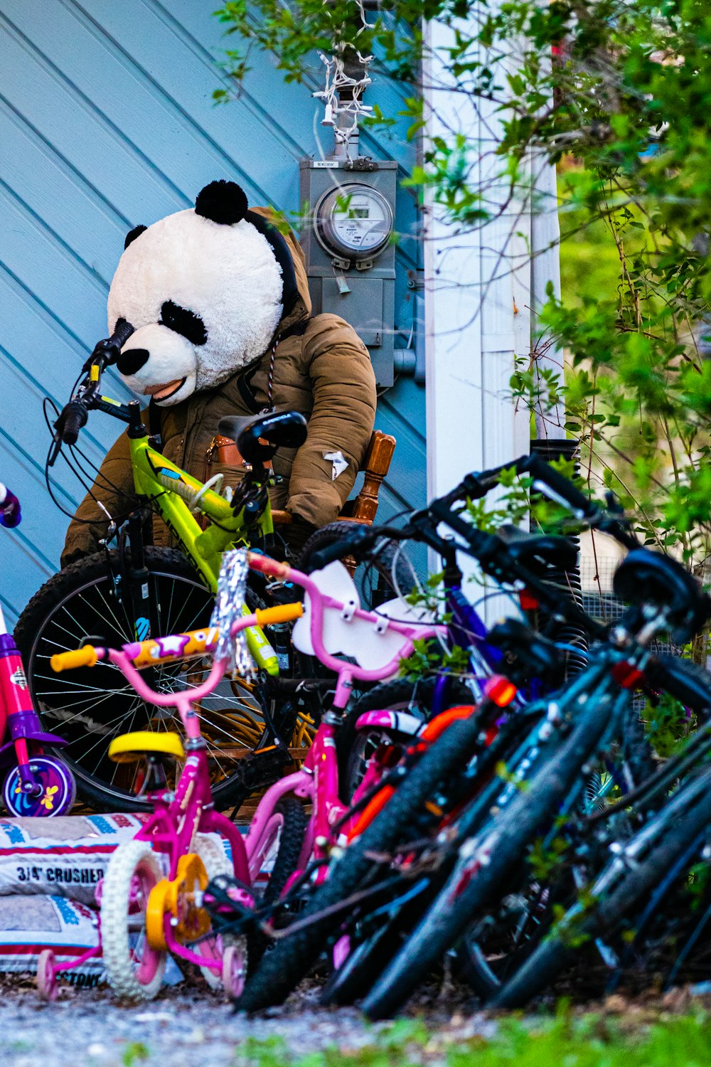 a panda bear sitting on top of a pile of bikes