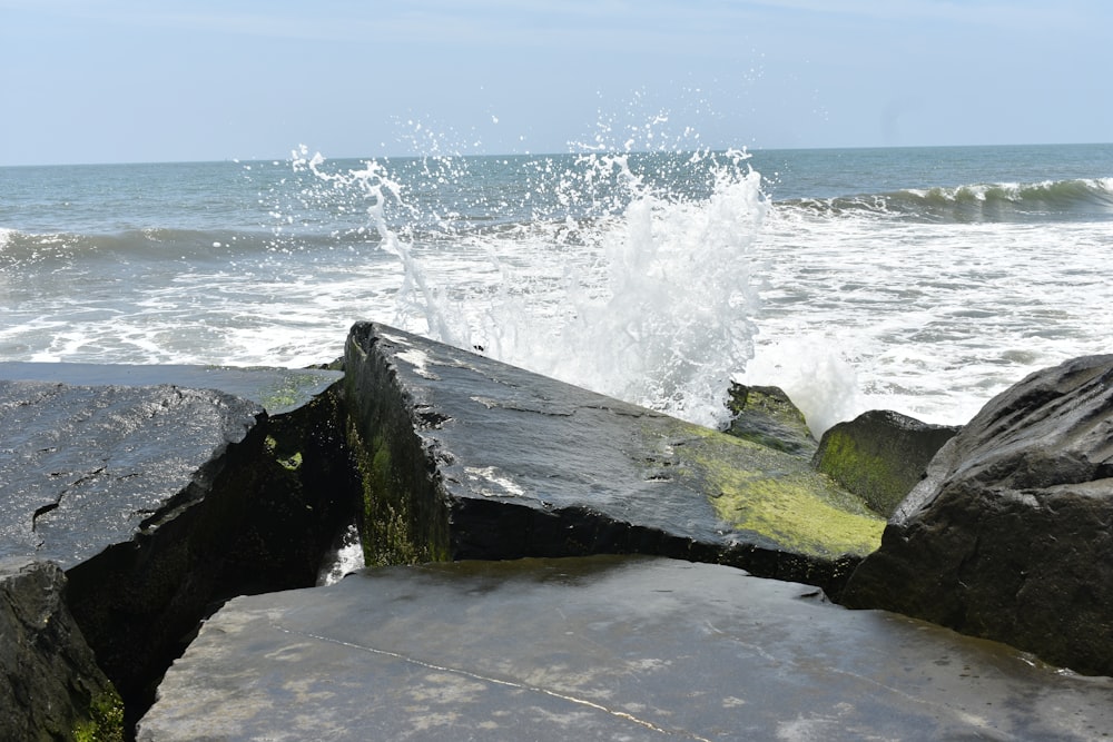 a rock formation with a splash of water on top of it