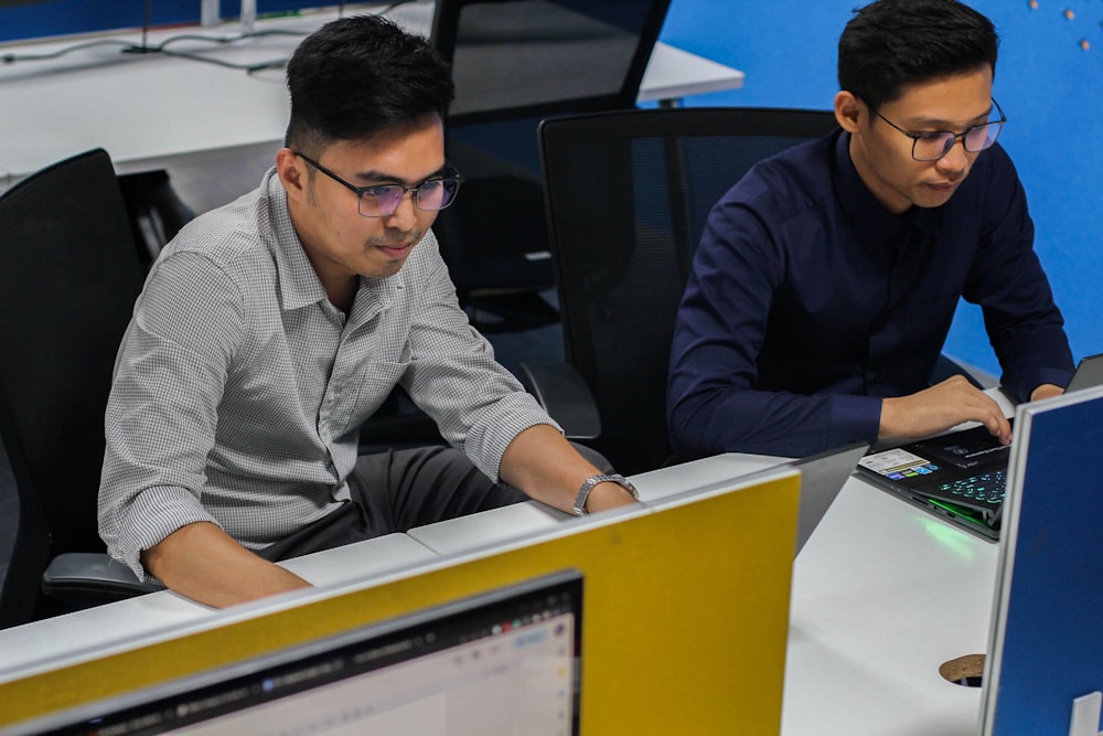 two men working on computers in an office