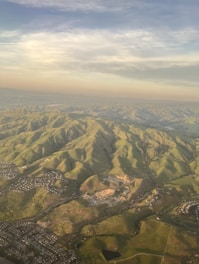 A serene aerial view of green residential plots bordered by lush hills in Haridwar.