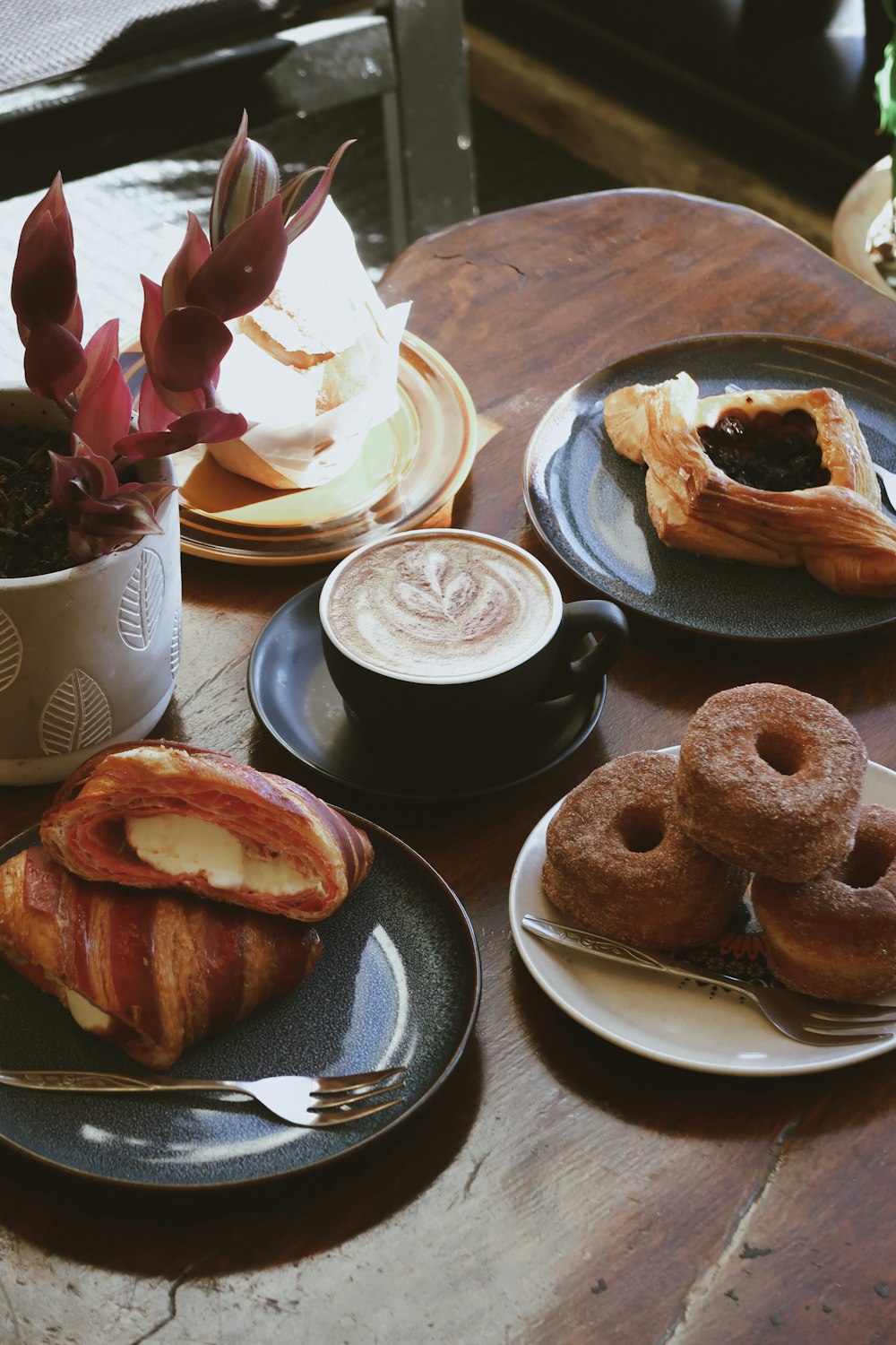 a table topped with plates of food and a cup of coffee