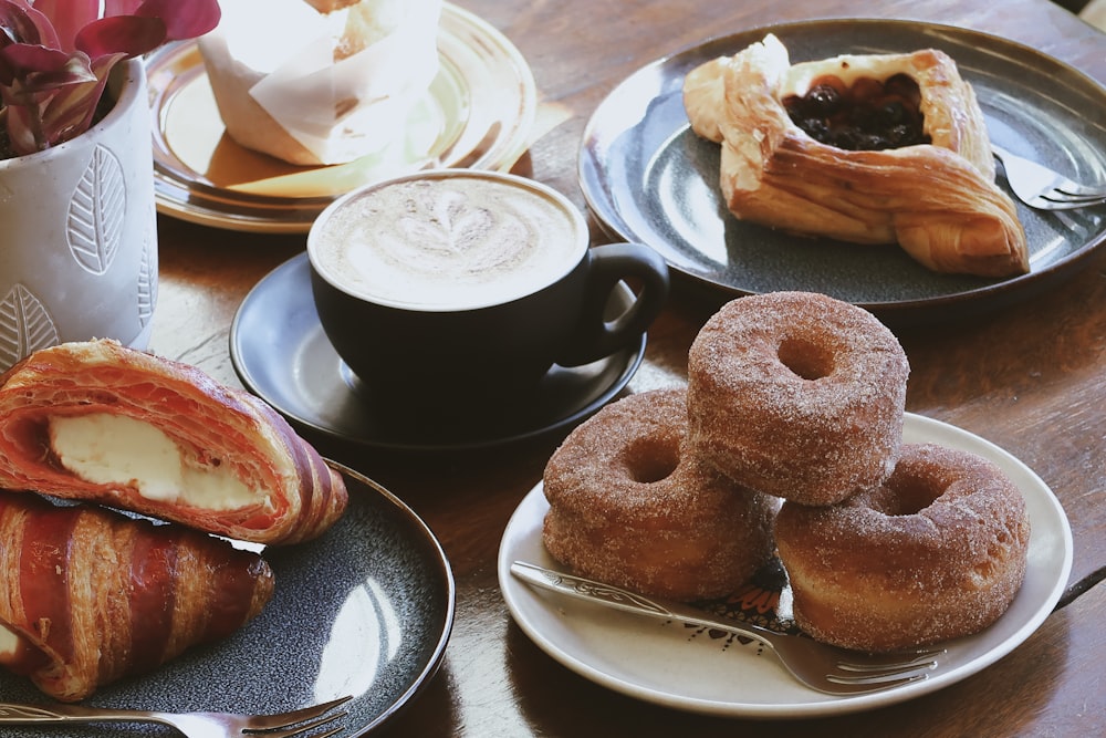 a table topped with plates of food and cups of coffee