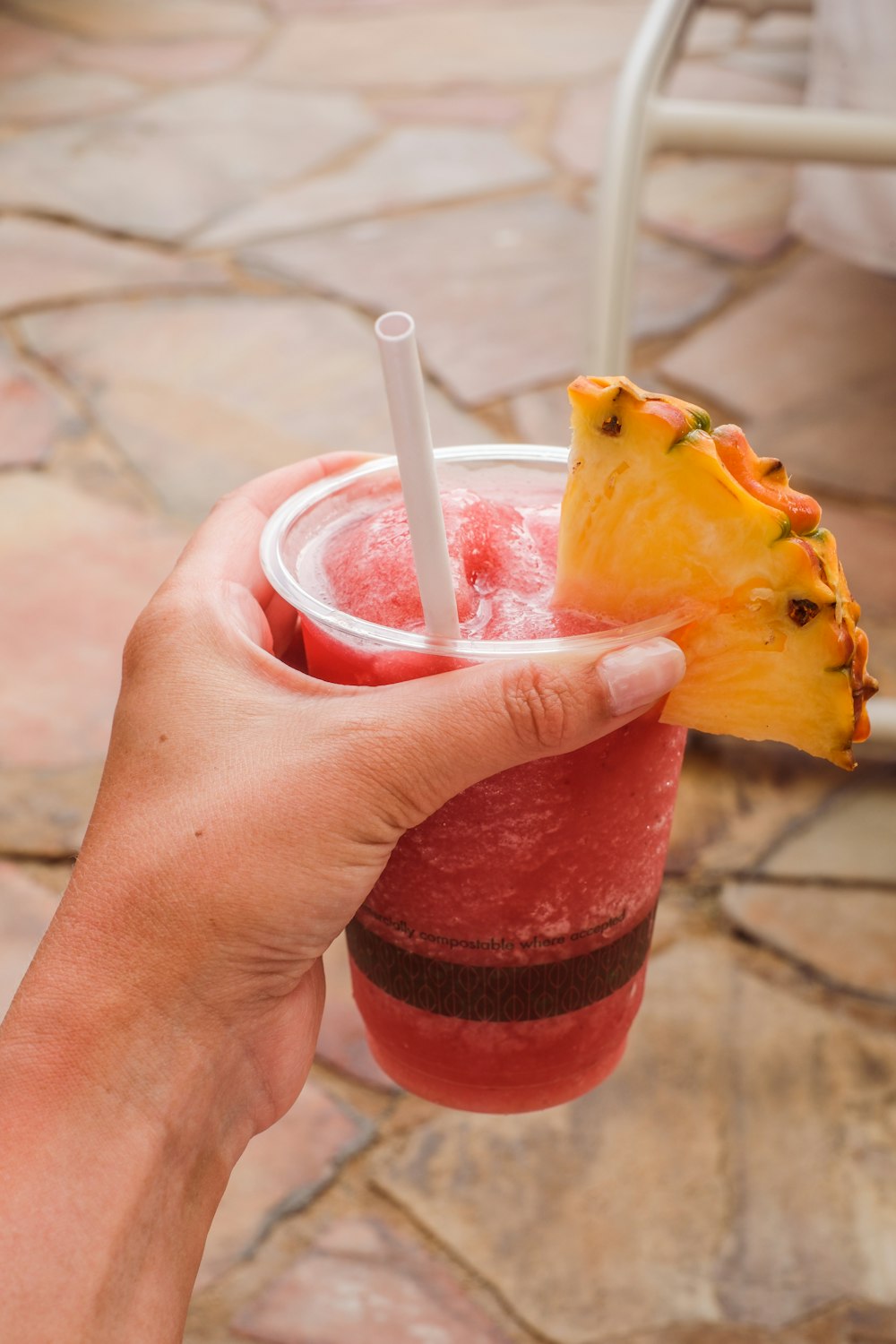 a person holding a drink with a pineapple on top