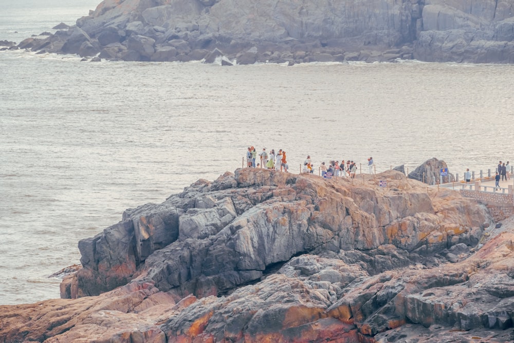 a group of people standing on top of a rocky cliff