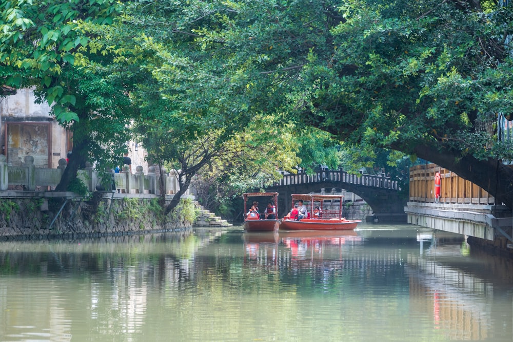 a boat traveling down a river next to a bridge