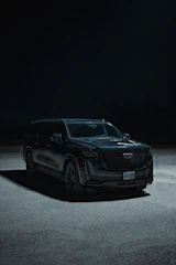 a black suv parked in a parking lot at night
