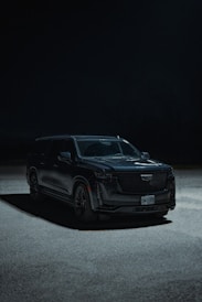a black suv parked in a parking lot at night