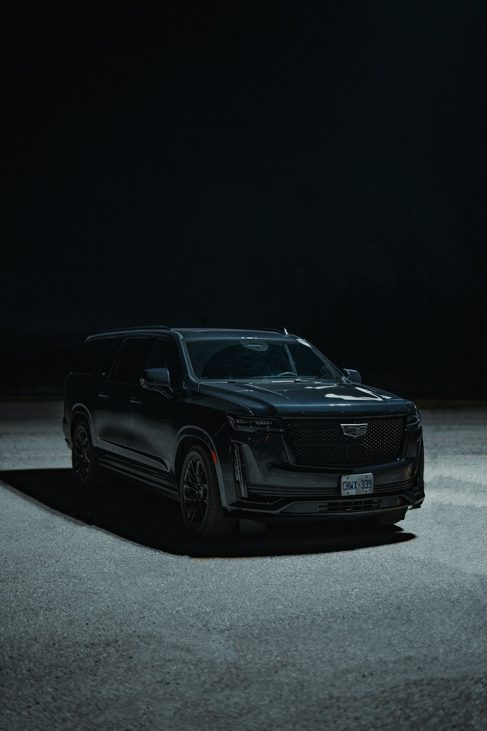 a black suv parked in a parking lot at night