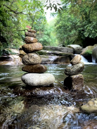Close-up of smooth stones stacked beside a gently flowing water feature.