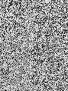 A detailed texture of a granite surface with a speckled pattern of gray, black, and white colors.