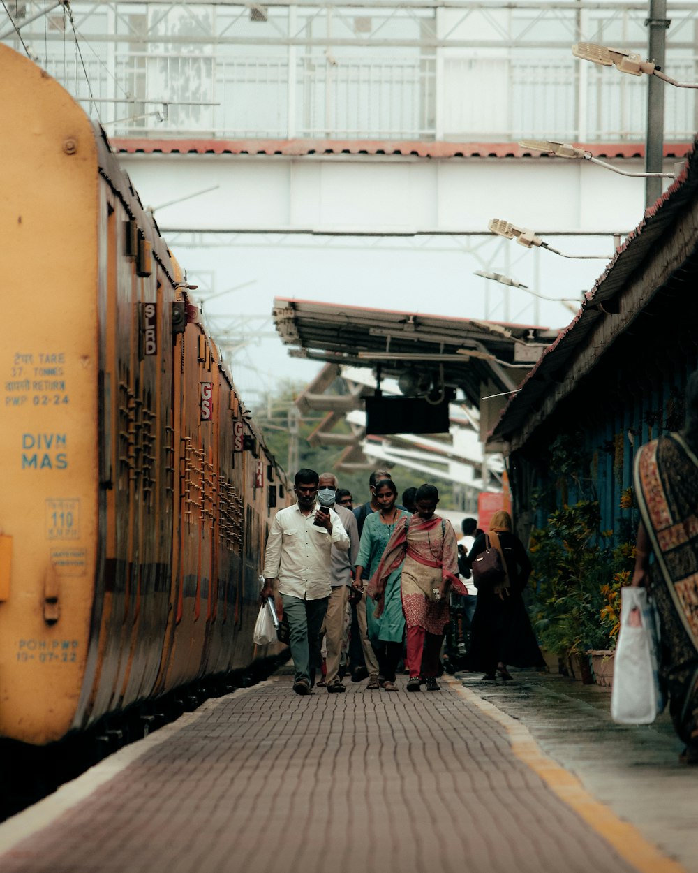 a group of people walking next to a train