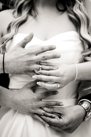 Detail shot of hands intertwined, symbolizing connection and celebration at a wedding.