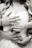 Multiple hands with rings are gently placed around a bride in a wedding dress, capturing an intimate moment. The image is in black and white, focusing on the close-up of hands and rings, symbolizing marriage and connection.
