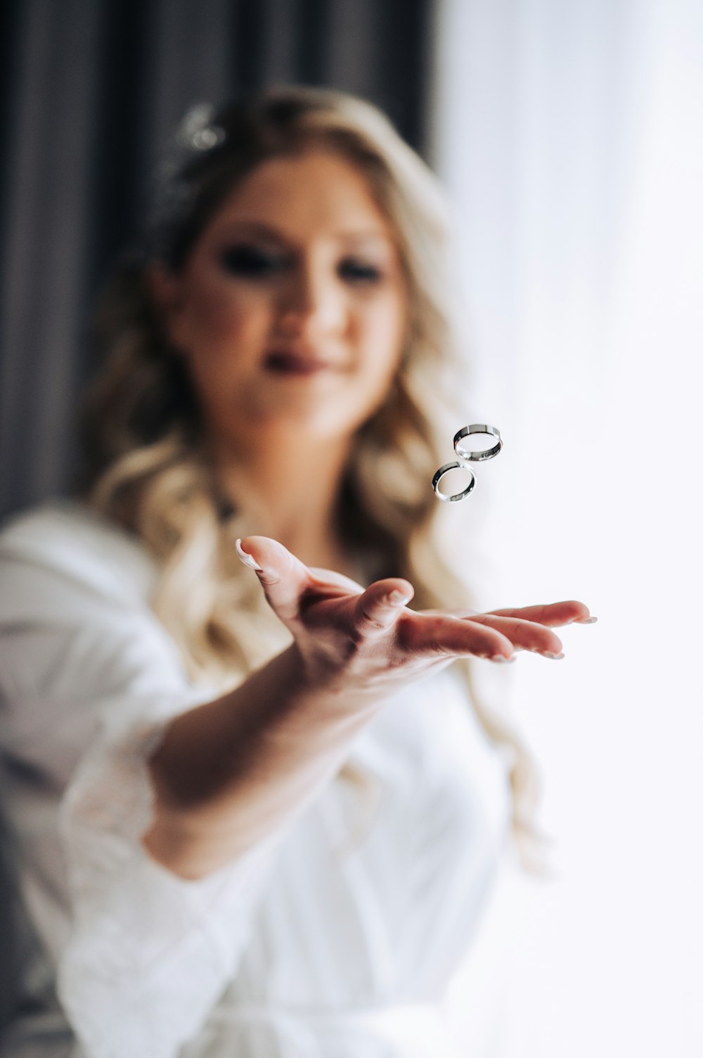 a woman in a white dress holding out her hand