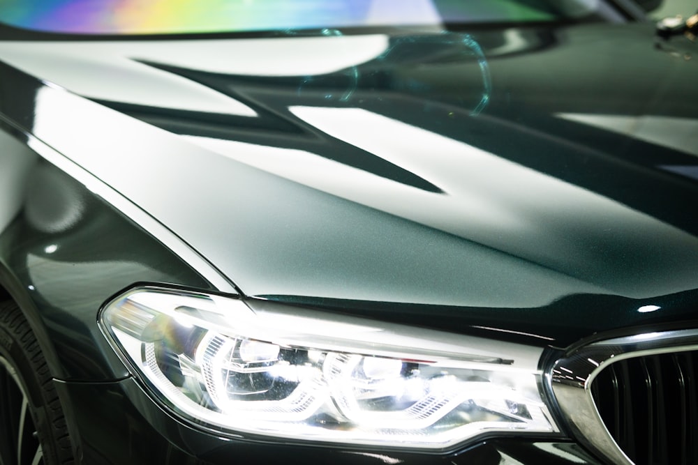 a close up of a black car with a rainbow light on it