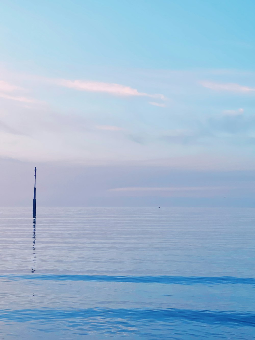 a large body of water sitting under a blue sky