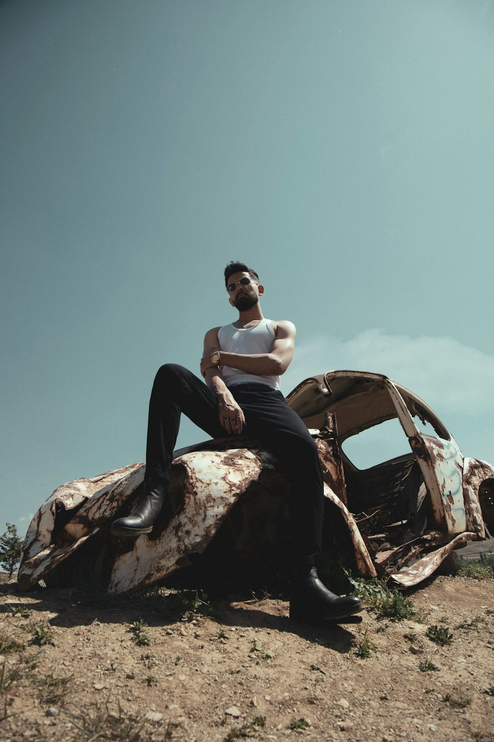 a man sitting on top of a rusty car