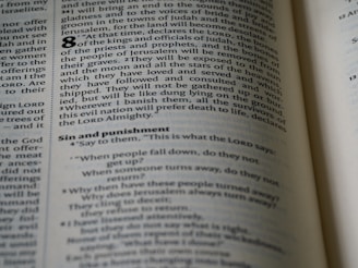 An open page of a book, likely a Bible, with text printed in columns. The section features prominent headings and verse numbers, with some words highlighted in bold.