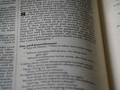 An open page of a book, likely a Bible, with text printed in columns. The section features prominent headings and verse numbers, with some words highlighted in bold.