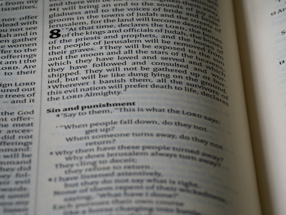 An open page of a book, likely a Bible, with text printed in columns. The section features prominent headings and verse numbers, with some words highlighted in bold.