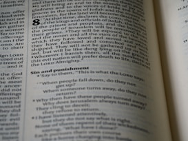 An open page of a book, likely a Bible, with text printed in columns. The section features prominent headings and verse numbers, with some words highlighted in bold.