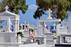 a bunch of white graves with flowers on them