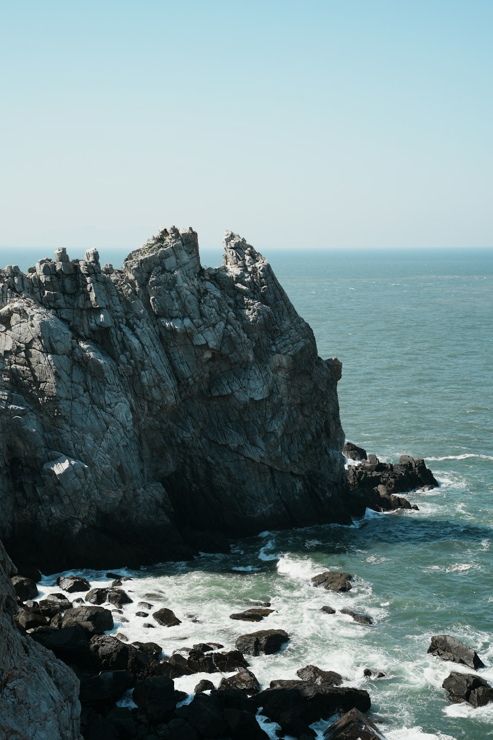a large rock outcropping next to the ocean
