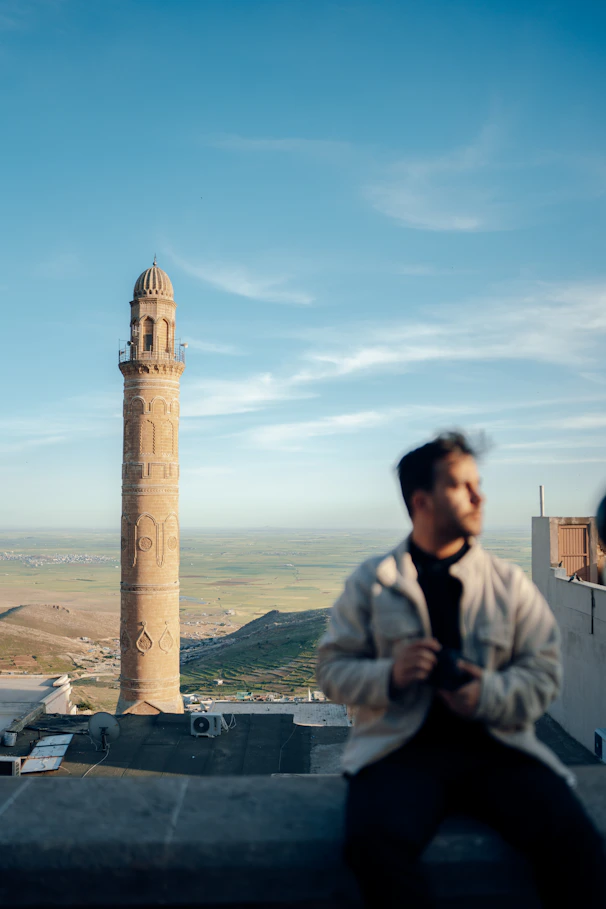 A scenic view of a famous Pakistani landmark with a traveler taking notes.