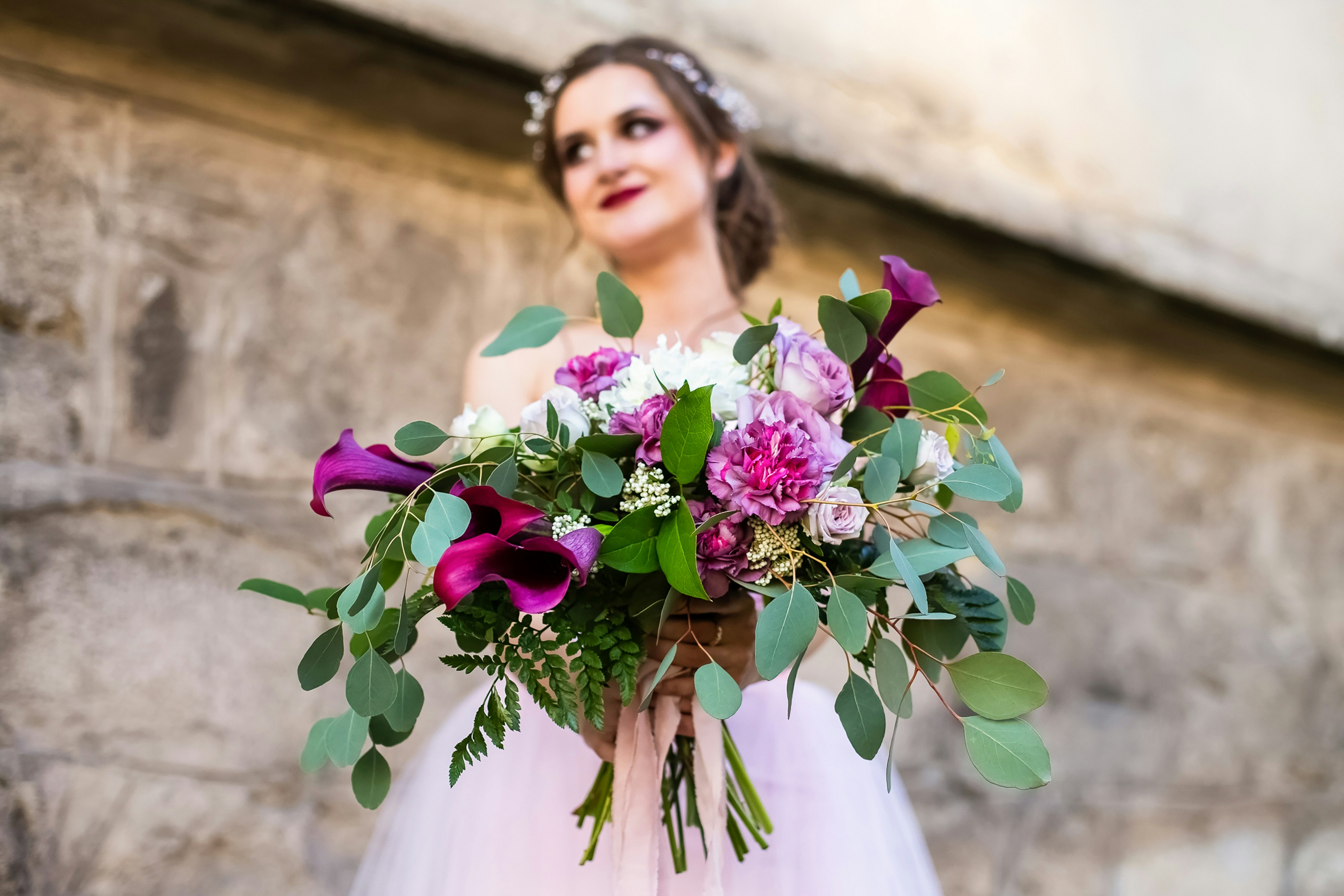 a woman in a wedding dress holding a bouquet of flowers