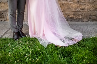 a bride and groom standing in front of a stone wall