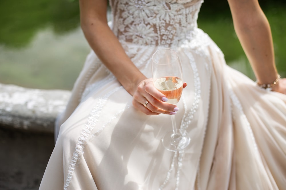 a woman in a wedding dress holding a wine glass