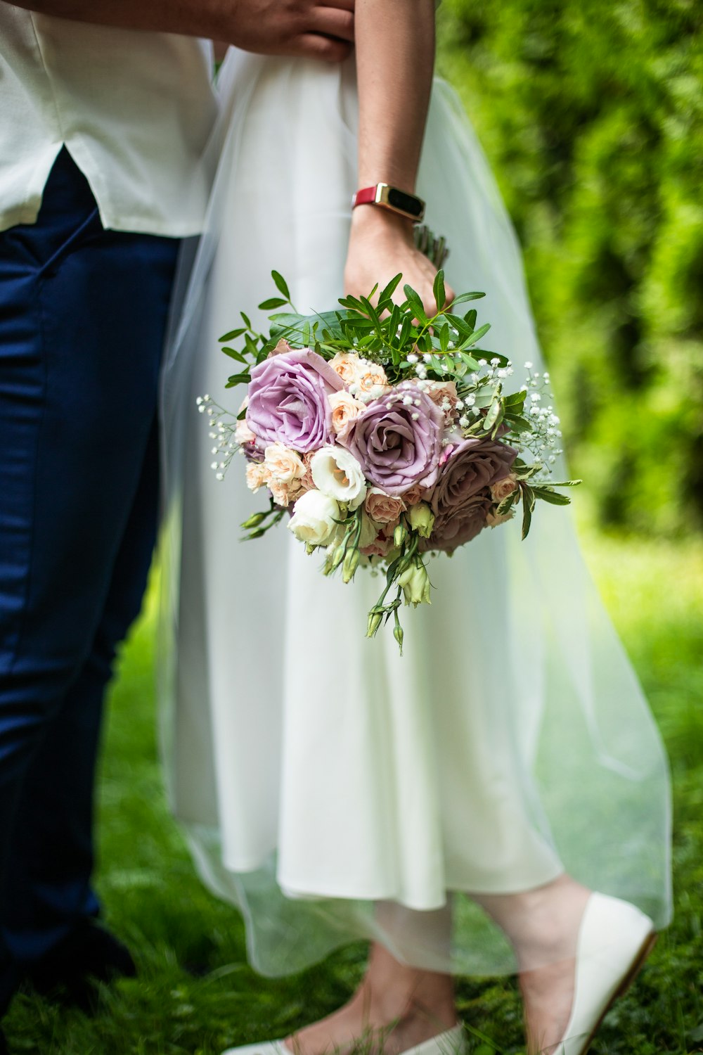 a close up of a person holding a bouquet of flowers