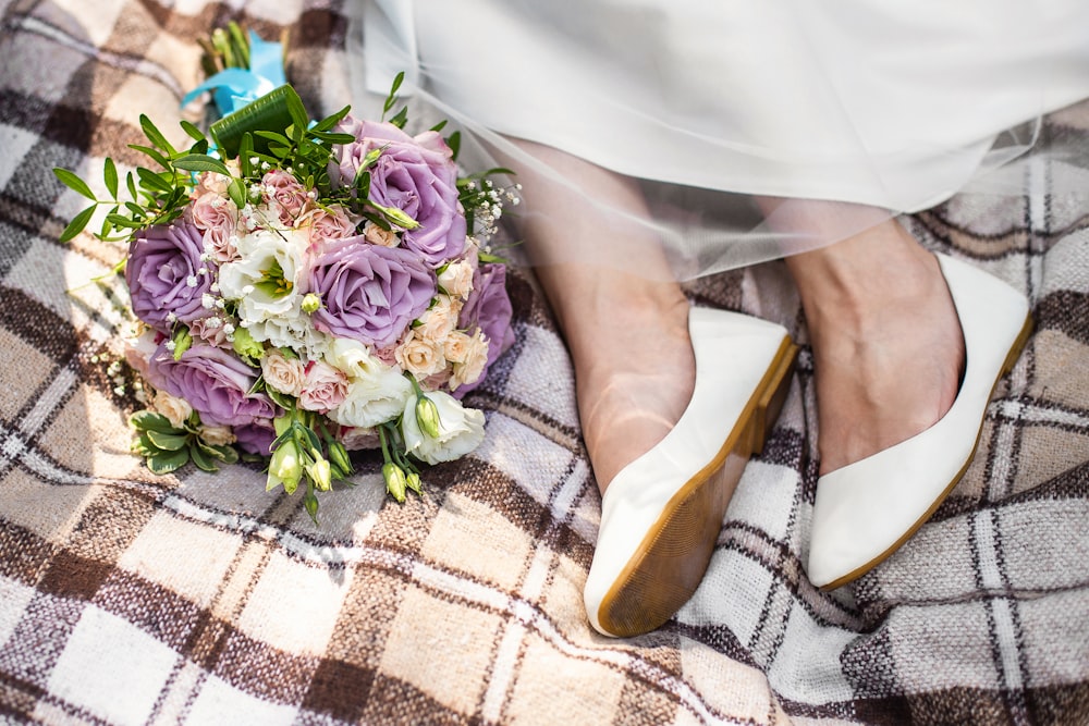 a bride's bouquet and shoes on a plaid blanket