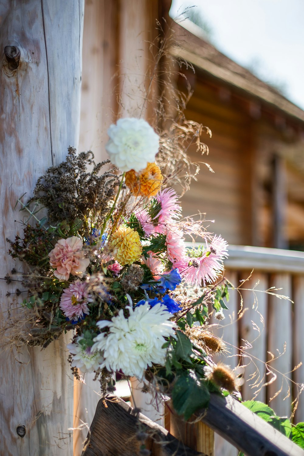 a bunch of flowers sitting on top of a wooden fence
