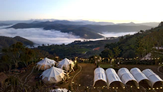A cozy campsite set against the backdrop of the Garhwal Himalayan range at sunset.