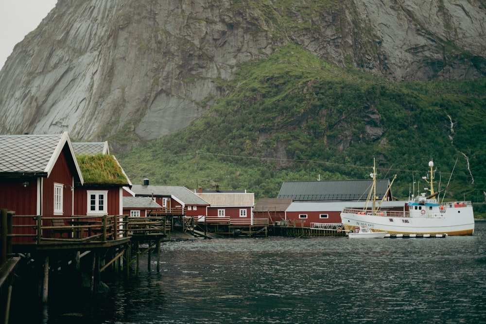 a boat docked at a dock in front of a mountain