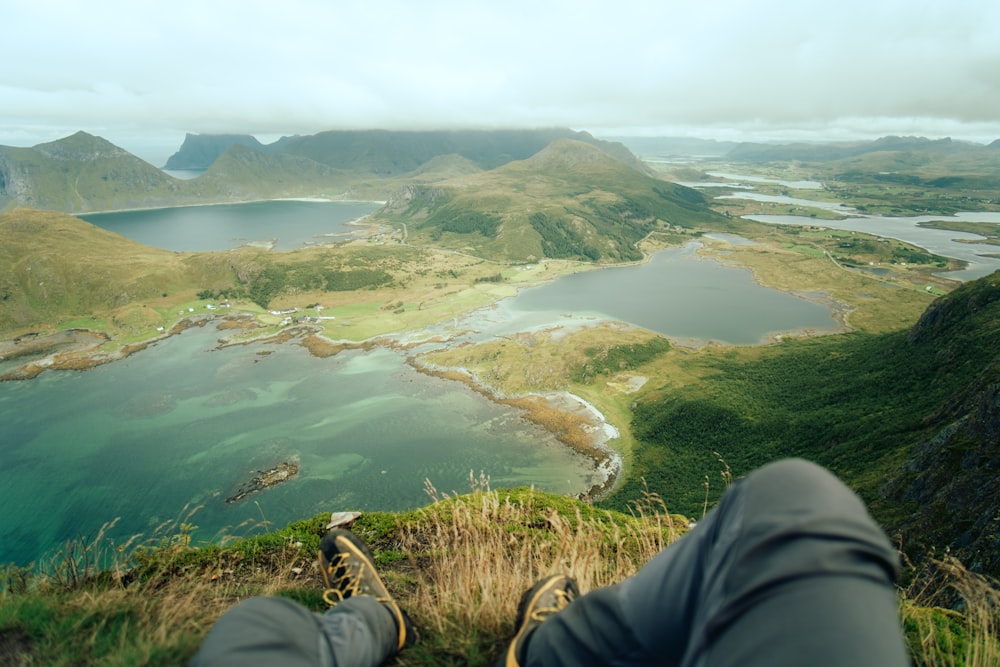 a person sitting on top of a lush green hillside